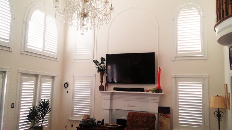 Salt Lake City great room with mounted television and arched windows.